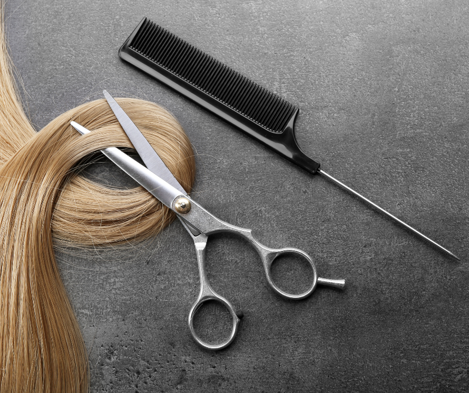 Stock image of a blonde hair lock, a pair of scissors and a tail comb